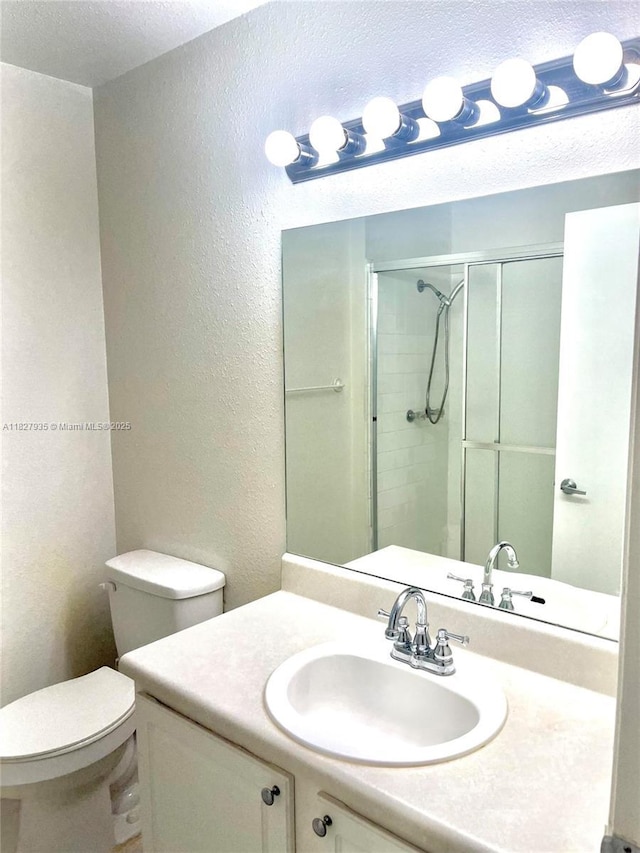 2331 NW 96th Ter Unit 17F, Pembroke Pines, FL 33024 - bathroom featuring a textured wall, vanity, and a shower with shower door