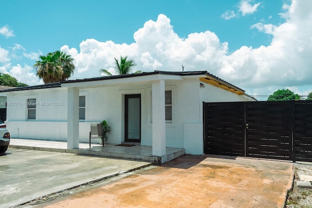 90 E 41st St, Hialeah, FL 33013 - view of front facade featuring stucco siding, a patio area, and a gate