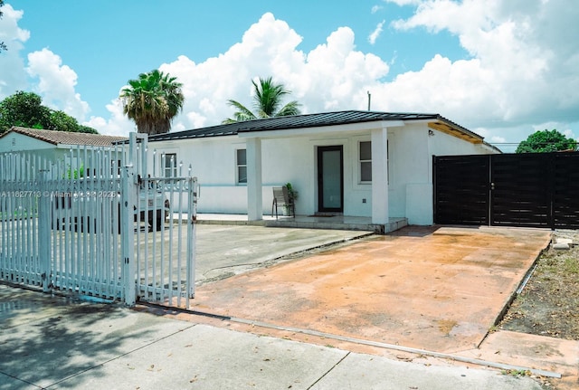 90 E 41st St, Hialeah, FL 33013 - view of front facade featuring a gate, stucco siding, a metal roof, and a standing seam roof