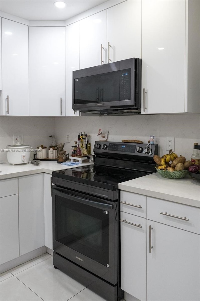 90 E 41st St, Hialeah, FL 33013 - kitchen featuring electric range, white cabinetry, light countertops, and light tile patterned floors