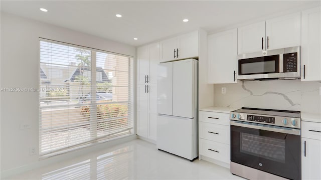 933 NE 24th Ave Unit 169, Hallandale Beach, FL 33009 - kitchen featuring appliances with stainless steel finishes, white cabinetry, tasteful backsplash, recessed lighting, and light tile patterned floors