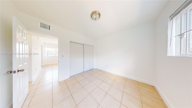 1190 NW 65th St, Miami, FL 33150 - unfurnished bedroom featuring a closet and light tile patterned flooring
