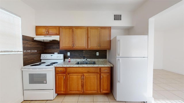 1190 NW 65th St, Miami, FL 33150 - kitchen with white appliances, under cabinet range hood, backsplash, brown cabinets, and light tile patterned floors