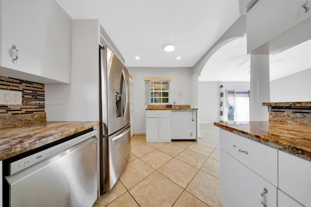 1115 NE 1st Ct Unit A, Hallandale Beach, FL 33009 - kitchen featuring appliances with stainless steel finishes, backsplash, white cabinets, light tile patterned flooring, and arched walkways
