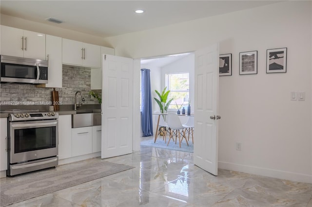 2125 SW 26th St, Miami, FL 33133 - kitchen with stainless steel appliances, tasteful backsplash, light marble finish floors, white cabinetry, and recessed lighting