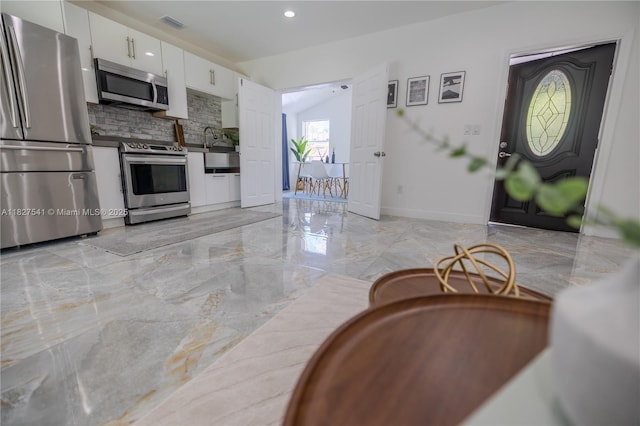 2125 SW 26th St, Miami, FL 33133 - kitchen with stainless steel appliances, white cabinetry, tasteful backsplash, light marble finish floors, and recessed lighting