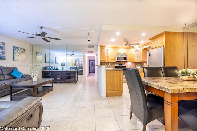 3021 Ventnor H Unit 3021, Deerfield Beach, FL 33442 - kitchen with appliances with stainless steel finishes, open floor plan, a ceiling fan, and decorative backsplash