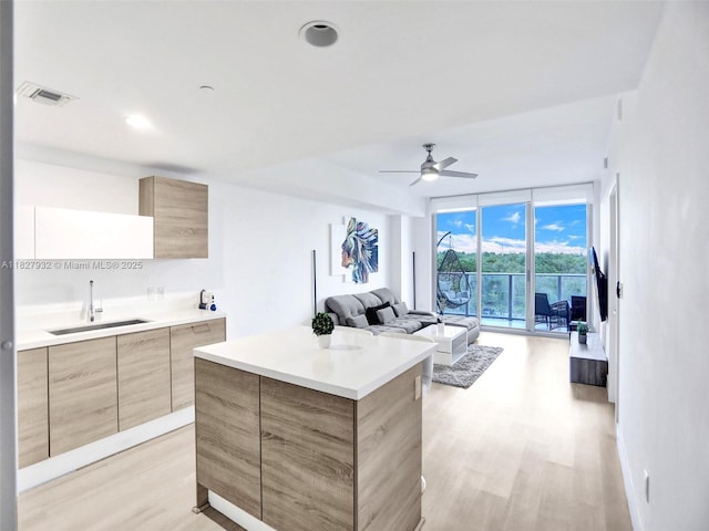 16385 Biscayne Blvd Unit 403, North Miami Beach, FL 33160 - kitchen featuring modern cabinets, light wood-style floors, light brown cabinetry, a ceiling fan, and a wall of windows