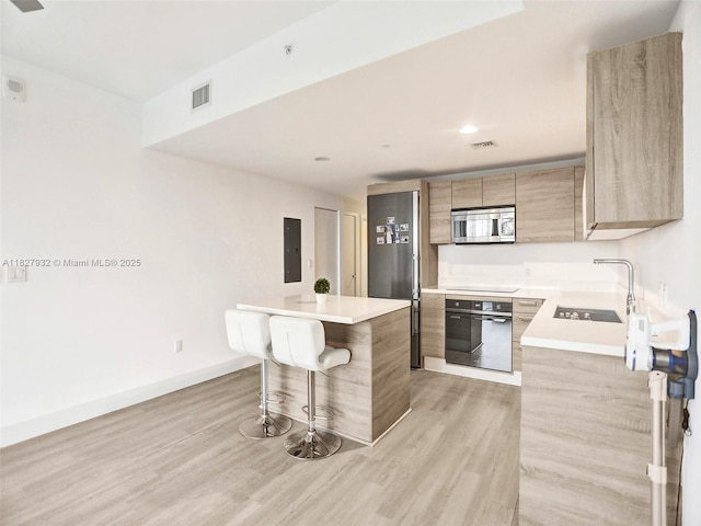 16385 Biscayne Blvd Unit 403, North Miami Beach, FL 33160 - kitchen featuring stainless steel appliances, a breakfast bar area, light wood finished floors, modern cabinets, and recessed lighting