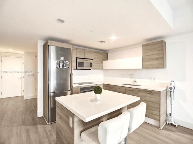 16385 Biscayne Blvd Unit 403, North Miami Beach, FL 33160 - kitchen with appliances with stainless steel finishes, modern cabinets, light wood-type flooring, light countertops, and a center island