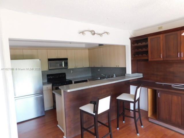 5900 SW 127th Ave Unit 3304, Miami, FL 33183 - kitchen featuring freestanding refrigerator, stainless steel microwave, black range with electric cooktop, and tasteful backsplash
