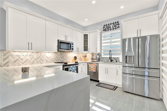 17709 SW 150th Ct, Miami, FL 33187 - kitchen with stainless steel appliances, white cabinetry, light stone counters, decorative backsplash, and recessed lighting