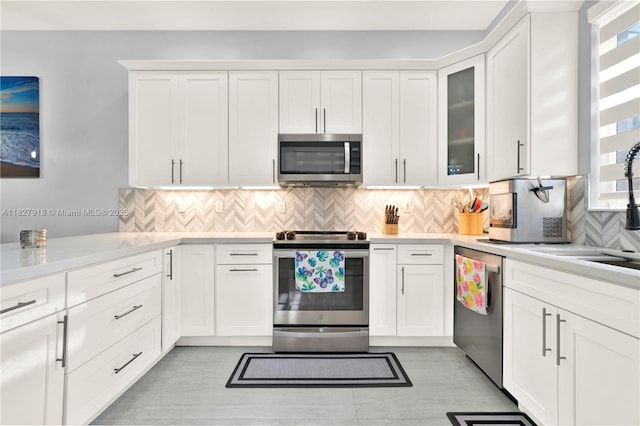 17709 SW 150th Ct, Miami, FL 33187 - kitchen with stainless steel appliances, white cabinetry, light countertops, and healthy amount of natural light