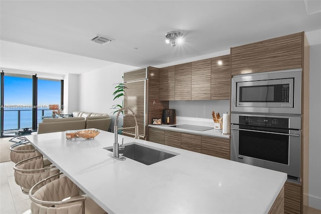 460 NE 28th St Unit 2407, Miami, FL 33137 - kitchen with stainless steel appliances, brown cabinets, light countertops, and modern cabinets