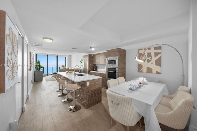 460 NE 28th St Unit 2407, Miami, FL 33137 - kitchen featuring appliances with stainless steel finishes, modern cabinets, brown cabinets, light countertops, and light wood-style flooring