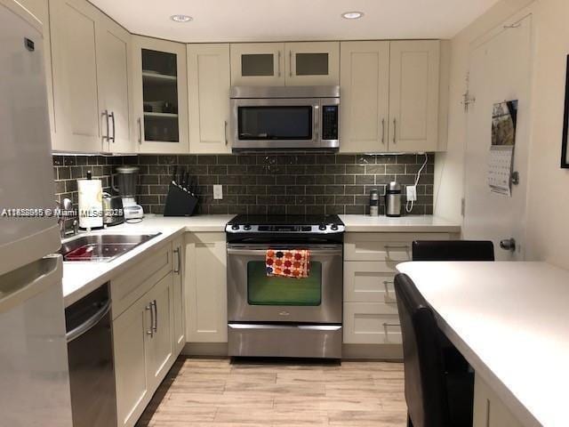 400 Kings Point Dr Unit 820, Sunny Isles Beach, FL 33160 - kitchen featuring appliances with stainless steel finishes, light countertops, decorative backsplash, and recessed lighting