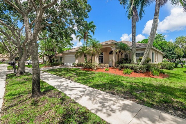 3843 Oak Ridge Cir, Weston, FL 33331 - mediterranean / spanish-style home featuring stucco siding, a garage, a front lawn, driveway, and a tile roof