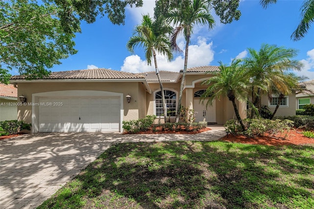 3843 Oak Ridge Cir, Weston, FL 33331 - mediterranean / spanish house with stucco siding, a garage, a tile roof, and decorative driveway