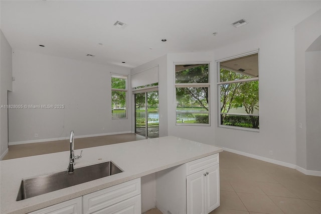 3843 Oak Ridge Cir, Weston, FL 33331 - kitchen featuring light tile patterned floors, white cabinetry, light countertops, open floor plan, and a water view