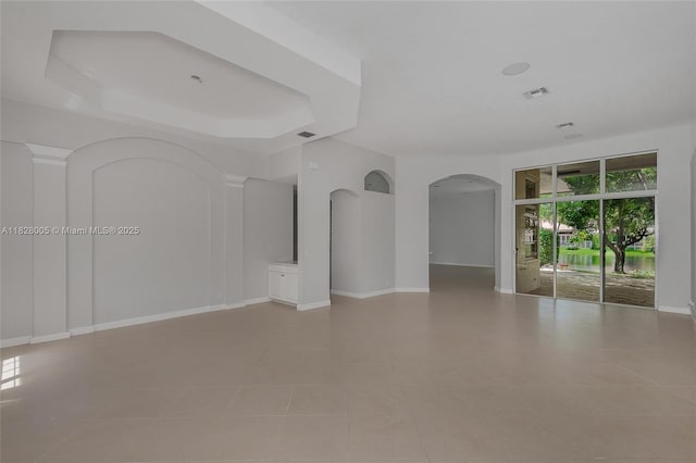3843 Oak Ridge Cir, Weston, FL 33331 - empty room with arched walkways, tile patterned flooring, and a raised ceiling