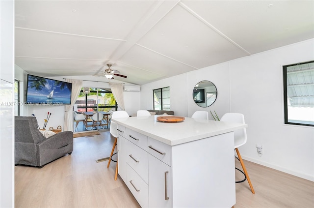 456 Bowie Ln, Key Largo, FL 33037 - kitchen with a breakfast bar, light wood-style floors, white cabinetry, a kitchen island, and ceiling fan