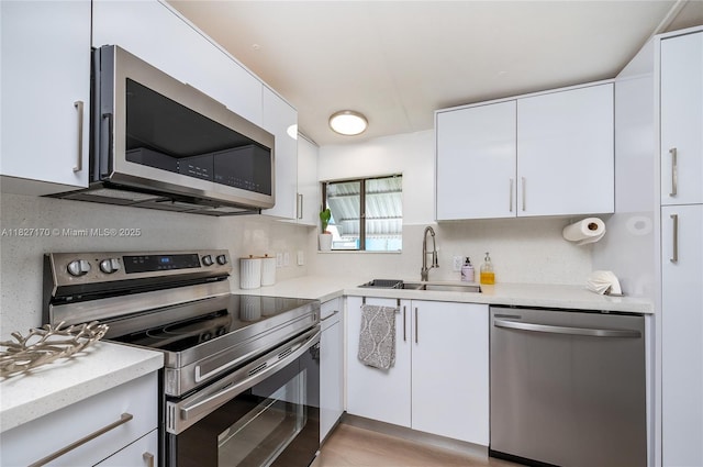 456 Bowie Ln, Key Largo, FL 33037 - kitchen featuring appliances with stainless steel finishes, white cabinets, decorative backsplash, and modern cabinets