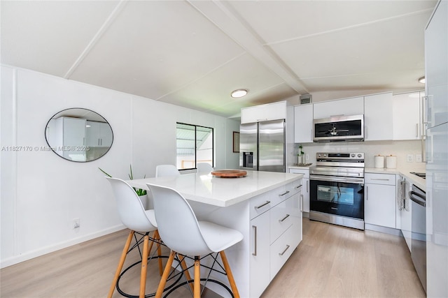 456 Bowie Ln, Key Largo, FL 33037 - kitchen with stainless steel appliances, light wood-style flooring, a breakfast bar, and modern cabinets