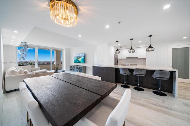 3400 SW 27th Ave Unit 1605, Miami, FL 33133 - dining area with light wood finished floors, recessed lighting, a chandelier, and a wall of windows