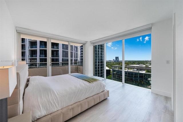 3400 SW 27th Ave Unit 1605, Miami, FL 33133 - bedroom with floor to ceiling windows, access to exterior, and wood finished floors