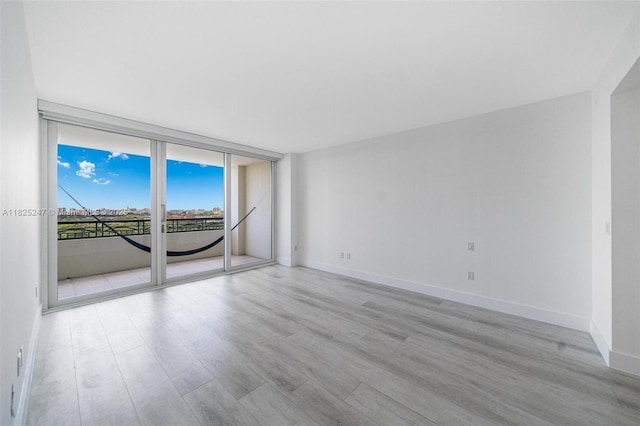 3400 SW 27th Ave Unit 1605, Miami, FL 33133 - empty room with light wood finished floors and expansive windows