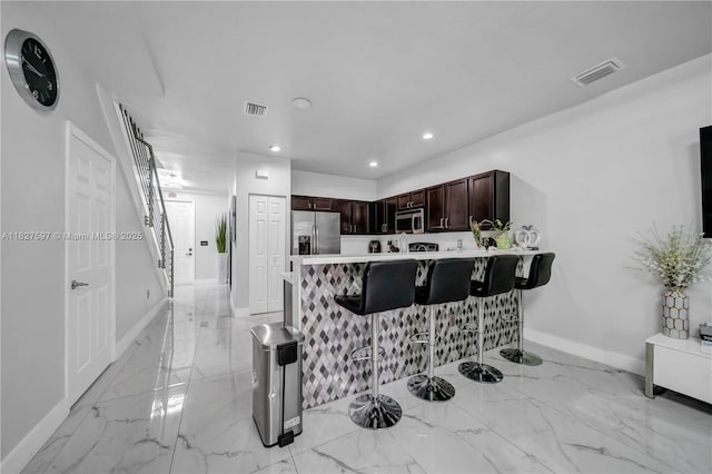 3574 W 88th Ter, Hialeah, FL 33018 - kitchen with appliances with stainless steel finishes, a kitchen breakfast bar, light marble finish flooring, light countertops, and recessed lighting