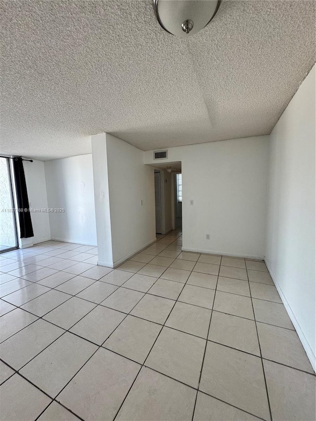12105 NE 6th Ave Unit 304, North Miami, FL 33161 - spare room featuring light tile patterned floors and a textured ceiling
