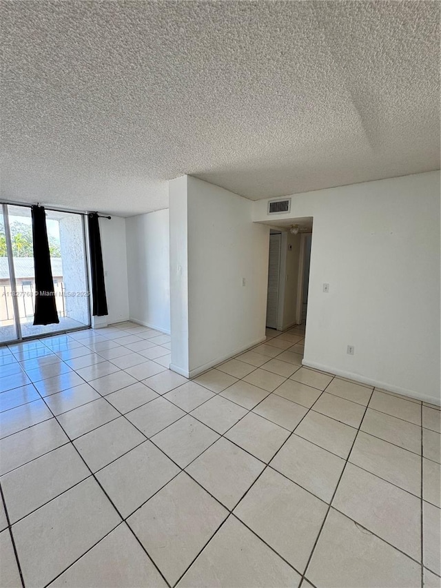 12105 NE 6th Ave Unit 304, North Miami, FL 33161 - spare room with a textured ceiling and light tile patterned floors