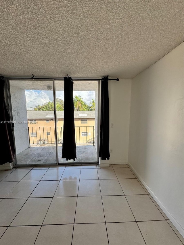 12105 NE 6th Ave Unit 304, North Miami, FL 33161 - spare room featuring healthy amount of natural light, a textured ceiling, and tile patterned flooring