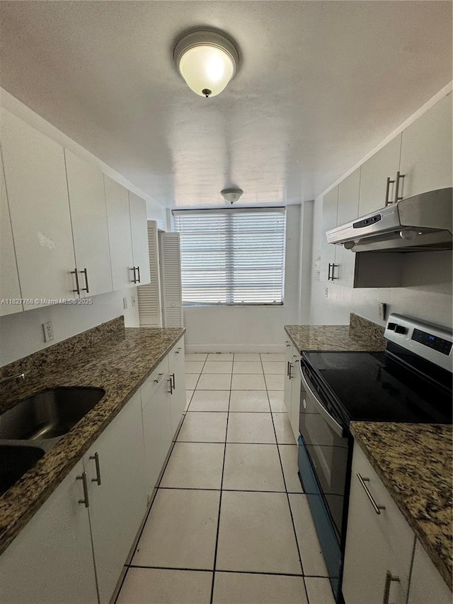 12105 NE 6th Ave Unit 304, North Miami, FL 33161 - kitchen featuring range with electric stovetop, under cabinet range hood, light tile patterned flooring, and white cabinetry