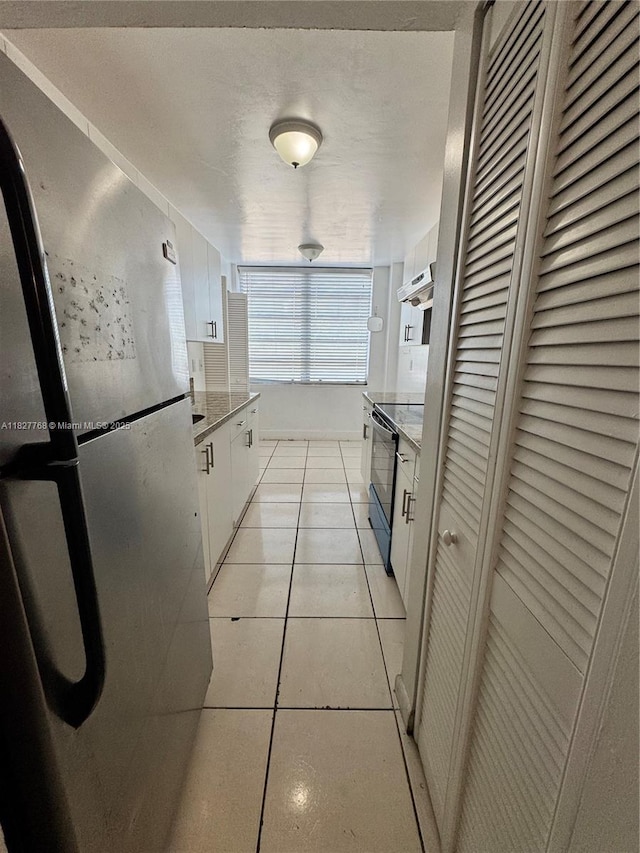 12105 NE 6th Ave Unit 304, North Miami, FL 33161 - kitchen featuring freestanding refrigerator, black electric range, under cabinet range hood, white cabinetry, and light tile patterned floors