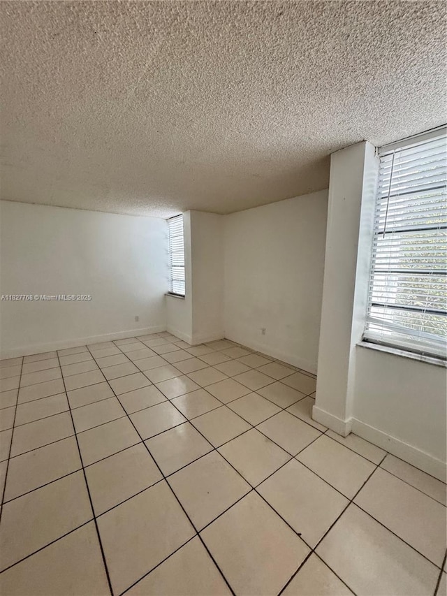 12105 NE 6th Ave Unit 304, North Miami, FL 33161 - spare room featuring a textured ceiling and light tile patterned flooring