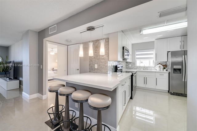 1500 S Ocean Dr Unit 7K, Hollywood, FL 33019 - kitchen featuring stainless steel appliances, a peninsula, backsplash, a breakfast bar area, and white cabinets