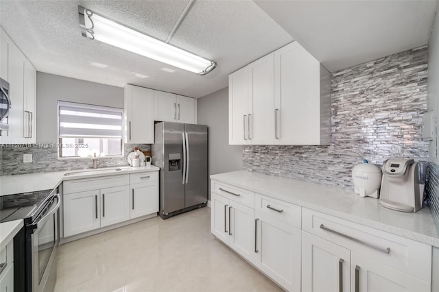 1500 S Ocean Dr Unit 7K, Hollywood, FL 33019 - kitchen featuring appliances with stainless steel finishes, backsplash, white cabinetry, and a textured ceiling