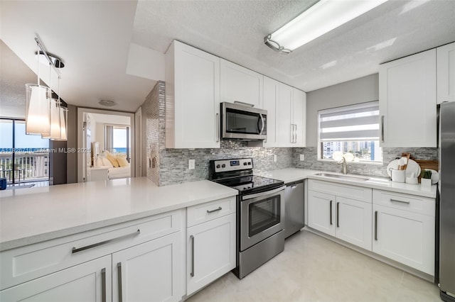 1500 S Ocean Dr Unit 7K, Hollywood, FL 33019 - kitchen with appliances with stainless steel finishes, backsplash, white cabinetry, light countertops, and a textured ceiling
