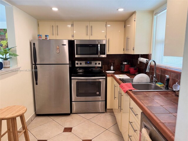 9365 Fontainebleau, Miami, FL 33172 - kitchen featuring appliances with stainless steel finishes, tile counters, tasteful backsplash, recessed lighting, and light tile patterned floors