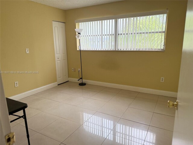9365 Fontainebleau, Miami, FL 33172 - tiled spare room with baseboards and a textured ceiling
