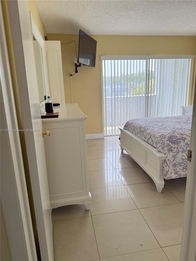 9365 Fontainebleau, Miami, FL 33172 - bedroom with light tile patterned floors, a textured ceiling, and access to outside