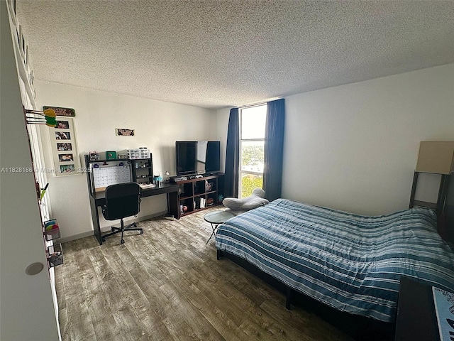 13499 Biscayne Blvd Unit 1013, North Miami, FL 33181 - bedroom with wood finished floors, a textured ceiling, and a desk