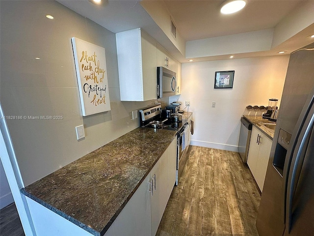 13499 Biscayne Blvd Unit 1013, North Miami, FL 33181 - kitchen featuring stainless steel appliances, white cabinets, dark wood finished floors, dark stone countertops, and recessed lighting