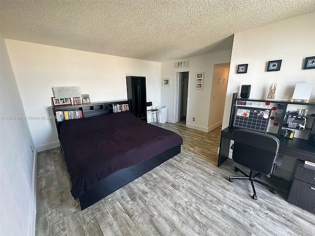 13499 Biscayne Blvd Unit 1013, North Miami, FL 33181 - bedroom with wood finished floors, a desk, and a textured ceiling
