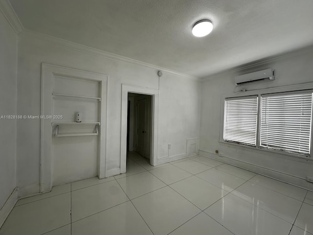 126 Mendoza Ave Unit 1, Coral Gables, FL 33134 - unfurnished bedroom with a wall unit AC, ornamental molding, a textured ceiling, and light tile patterned floors