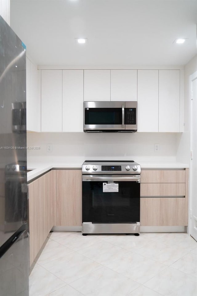 400 Kings Point Dr Unit 1222, Sunny Isles Beach, FL 33160 - kitchen featuring appliances with stainless steel finishes, modern cabinets, light brown cabinets, light countertops, and recessed lighting
