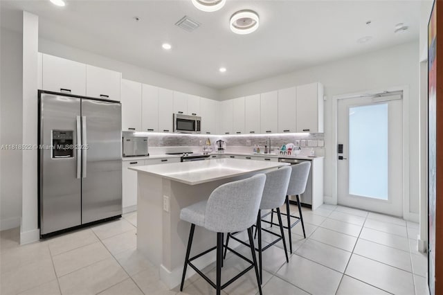 8001 NW 41st St Unit F-112, Doral, FL 33166 - kitchen with stainless steel appliances, a kitchen breakfast bar, light countertops, a kitchen island, and recessed lighting
