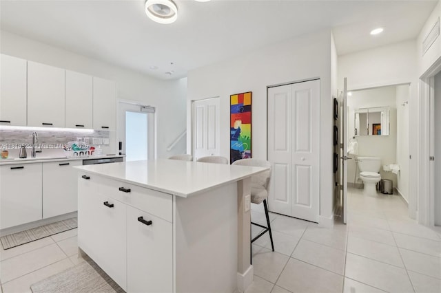 8001 NW 41st St Unit F-112, Doral, FL 33166 - kitchen featuring a kitchen bar, light tile patterned floors, tasteful backsplash, light countertops, and recessed lighting
